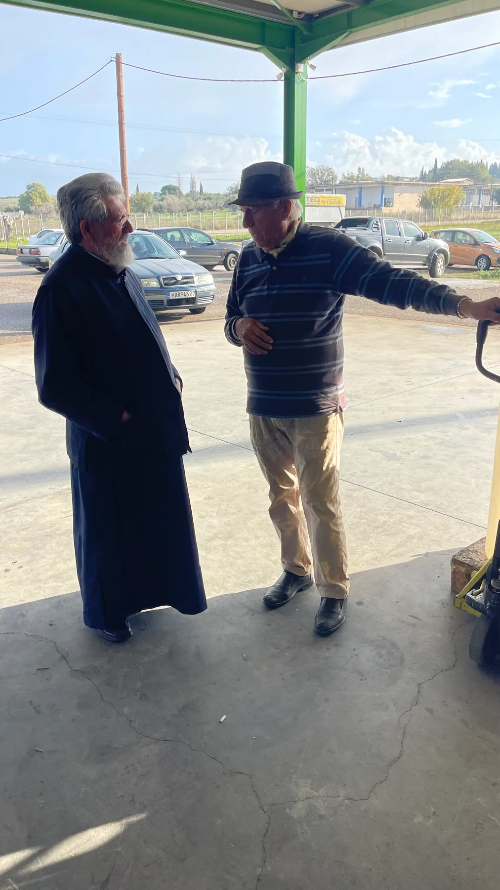 Ευάγγελος (Angelo) in conversation with the village priest at the depot