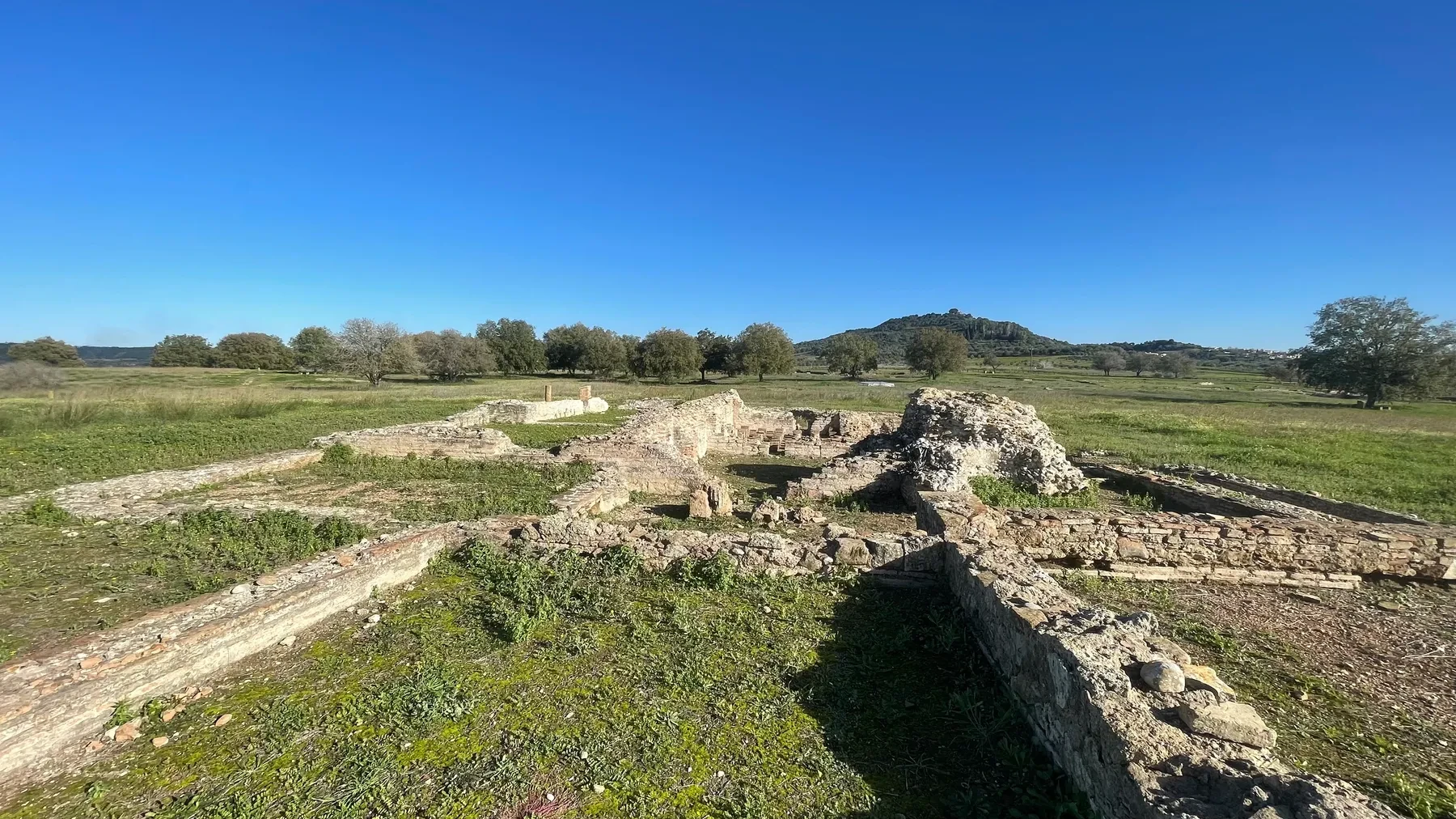 Foundation ruins at Ancient Elis with a rocky hillside beyond