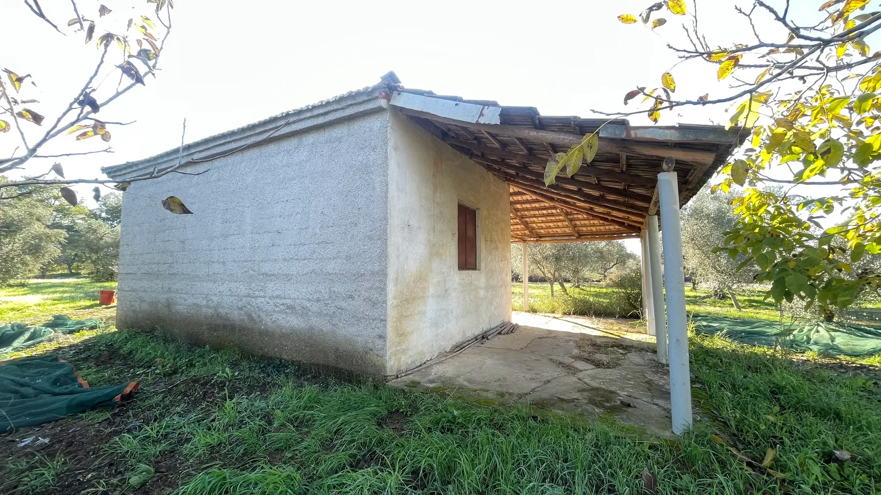 A close view of the original family house's whitewashed walls and covered porch