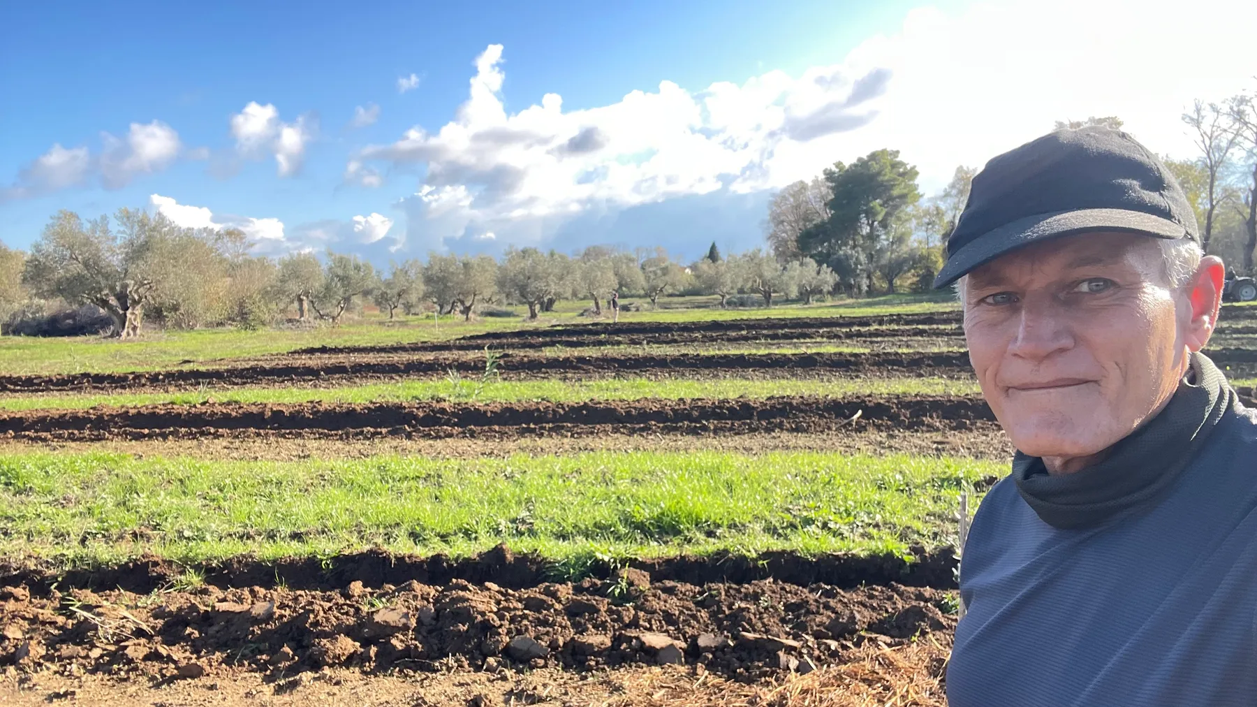 Ευάγγελος (Angelo) in the newly planted field, freshly tilled rows behind him