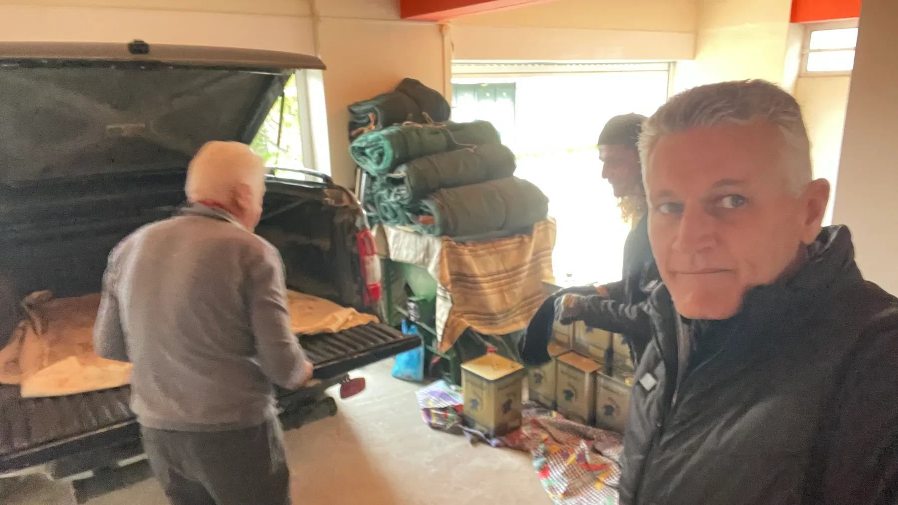 Ευάγγελος (Angelo) and Κωνσταντίνος (Konstantinos) packing a car full of tins, prepping a shipment of oil for cousin Πέτρος (Peter, Canada)