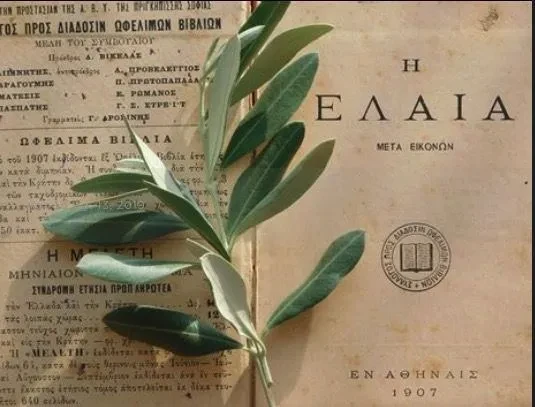 A 1907 Greek book titled Η ΕΛΑΙΑ (The Olive) with a fresh olive branch laid across it