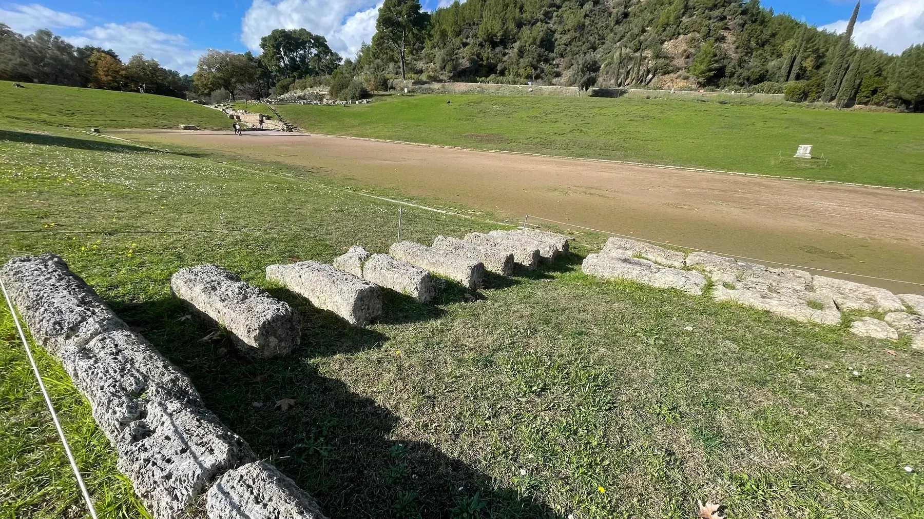 The ancient running track at Olympia, with the stone starting-line blocks in the foreground