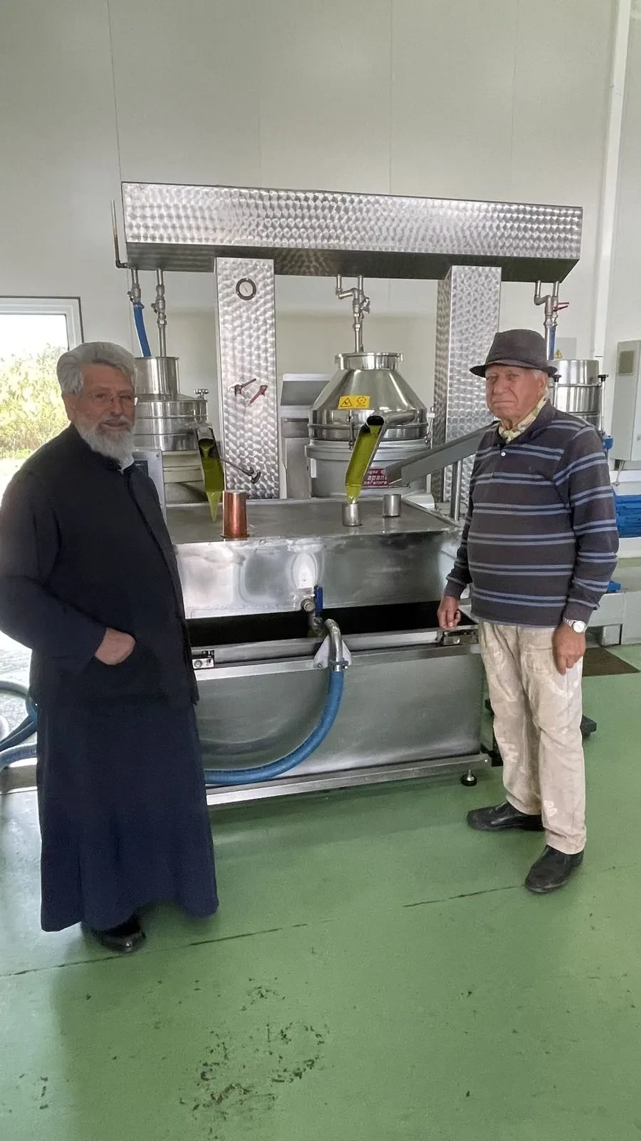 The priest and Angelo beside the press before the harvest begins