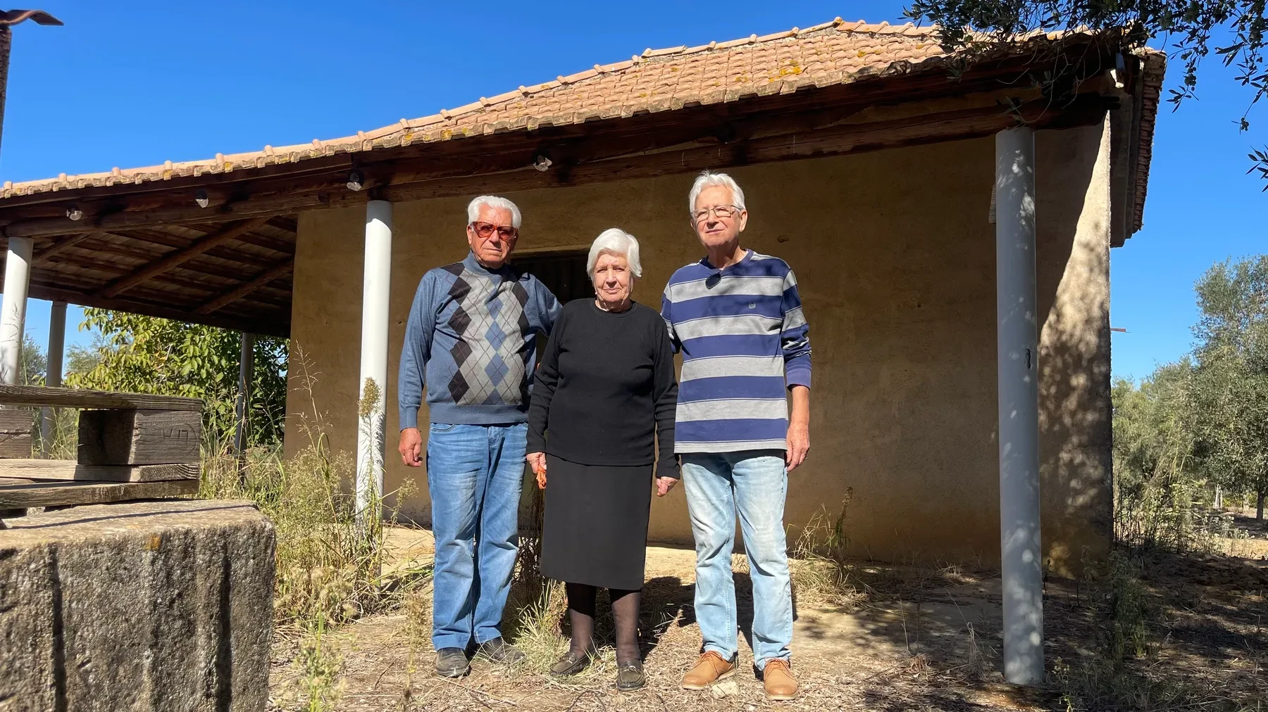 Ευάγγελος (Angelo), Γεωργίνα (Georgina), and Νικόλαος (Nick) standing outside their parents' original house