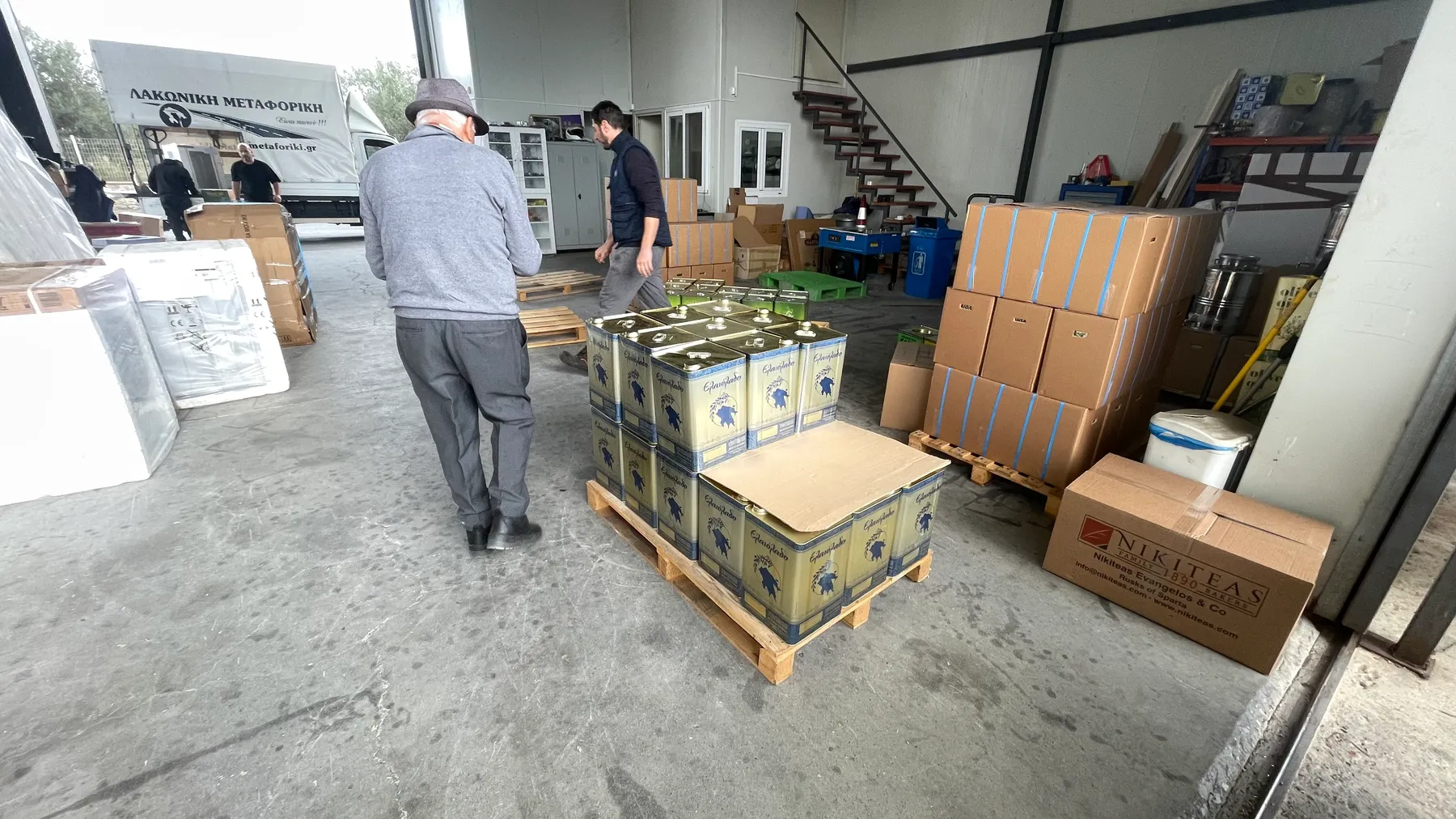 Angelo at the Laconian Transport depot in Sparta, pallets of oil tins ready for shipment