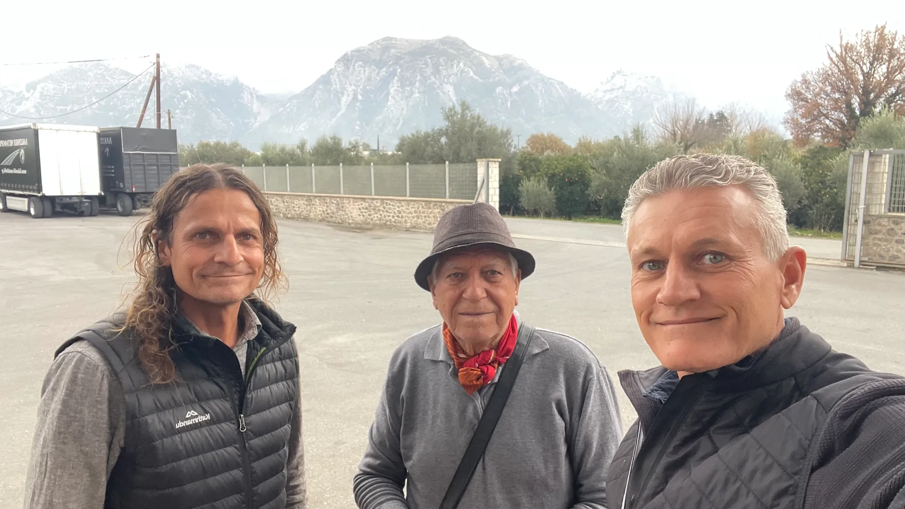 Alexandros, Angelo, and Konstantinos together at the depot, the Taygetus mountains behind them