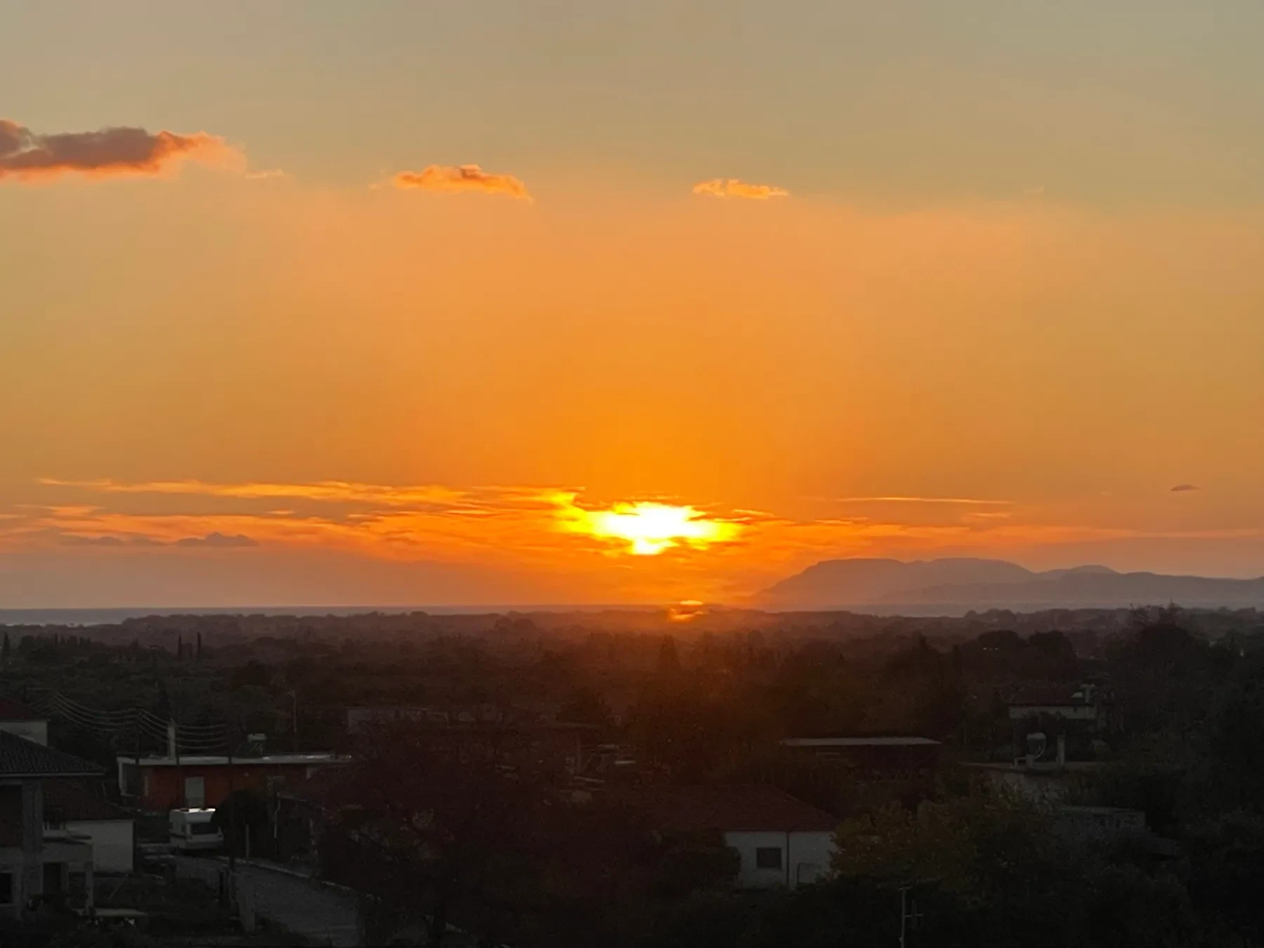 Sunset over the village of Chavari, red-tiled roofs and distant mountains